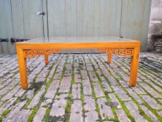 A Chinese teak coffee table with plate glass top and drop-in panels salvaged shutters from a house