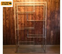 A chrome and glass etagere open bookcase in the manner of Milo Baughman. H.200 W.120 D.42cm.