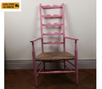A distressed painted ladderback armchair with rush seat of compact size. Seat height 34cm.