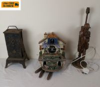 A Swiss style chalet clock, a carved figural table lamp and a 19th century clock case and