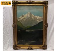 A C.1900 oil on board depicting a cabin on a lake in a mountainous landscape, framed and glazed.