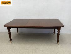 A William IV style mahogany extending dining table with extra leaf on reeded tapering supports