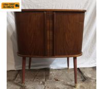 A mid-century teak record cabinet with d-end top over a pair of sliding tabour doors raised on