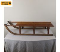 A vintage beechwood sledge with metal bindings by Grays of Cambridge. H.24 L.114 W.32 cm.
