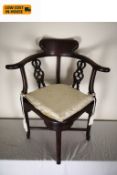 A Chinese hardwood corner chair fitted with squab cushion on stretchered supports. H.84cm.