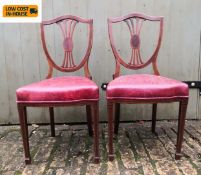 A pair of mahogany shield back dining chairs in leather upholstery. H.91cm.