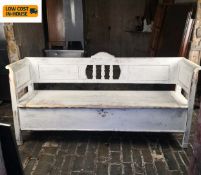 A 19th century distressed painted Scandinavian hall bench with outswept arms and hinged seat. H.