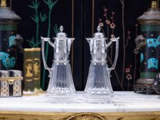 A PAIR OF LATE 19TH CENTURY GERMAN SILVER AND GLASS CLARET JUGS