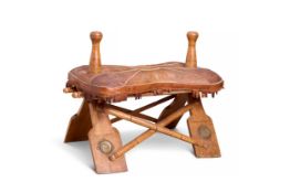 A LEATHER AND WOOD CAMEL SADDLE STOOL