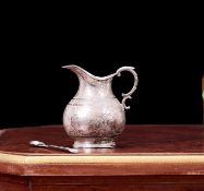 AN INDIAN SILVER MILK JUG AND SPOON