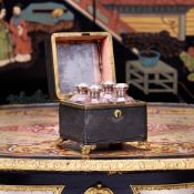 A SET OF 18TH CENTURY GLASS COLOGNE BOTTLES IN LEATHER DISPLAY CASE