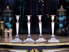 A SET OF FOUR EARLY 20TH CENTURY STERLING SILVER CANDLESTICKS C. 1910
