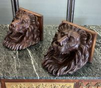 A PAIR OF 19TH CENTURY CARVED WALNUT WALL BRACKETS MODELLED AS LIONS