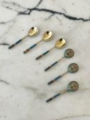 A SET OF SIX RUSSIAN SILVER GILT AND ENAMELLED SPOONS