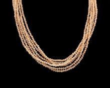 A three-strand blush pink coral necklace.