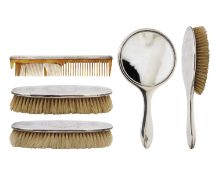 A George V silver five piece dressing table set by William Aitken.