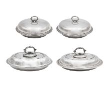 A pair of silver-plated graduated food domes, two oval trays, and an oval galleried tray.