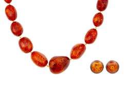 A large graduated heat-treated cognac amber bead necklace with a pair of earrings.