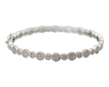 A silver hinged bangle set with CZ clusters.
