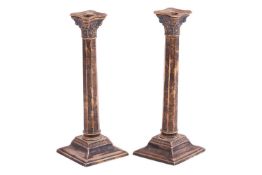 A pair of silver Corinthian column candlesticks, the detachable sconces with beaded borders, the tap