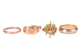 A group of four rings; to include a Modernist textured dress ring of bamboo design, in yellow metal 