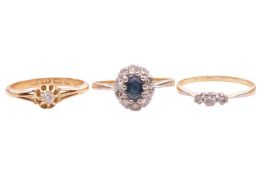 Three gem-set rings; comprising a sapphire and diamond cluster ring, in bi-colour metal marked '18ct