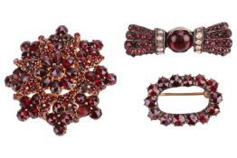 Three Bohemian garnet brooches; to include a starburst cluster brooch set with faceted red garnets, 