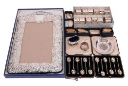 A small group of items comprising a set of twelve napkin rings with foliate banding, in white metal 