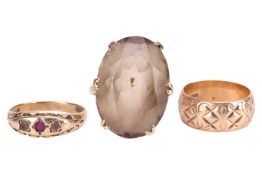 A group of three rings; The first an oval-cut smoky quartz measuring 26.0mm x 18.0mm x 10.7mm, claw-