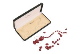 An amber bead necklace and a single-strand cultured pearl necklace by Mikimoto, the broken strand of