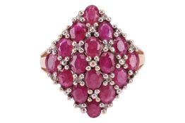 A ruby and diamond dress ring in 9ct gold, comprising sixteen oval-cut rubies set within a lattice d