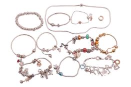 A small group of branded jewellery items comprising Pandora bracelets with assorted charms, a single