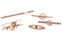 Five brooches; comprising an American cowboy-inspired bar brooch, depicting a rifle and hanging cowb