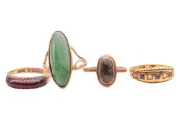 A collection of four gem-set rings; one set with a lozenge-shaped green hardstone: another with a bl