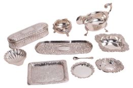 A small collection of ornated silver items; to include a sauceboat with scrolled handle on hoofed fe