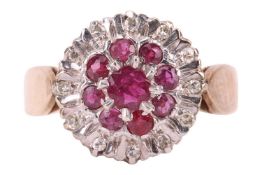 A 9ct gold ruby and diamond cluster ring comprising a central claw-set round mixed-cut ruby encircle