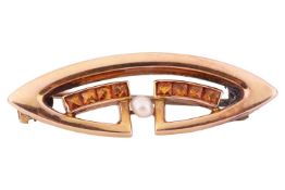 A citrine and seed pearl brooch, comprising a seed pearl flanked by two channels of four mixed-cut s
