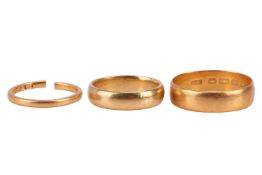 Three 22ct gold band rings, one 5.95mm wide, size W ½, another 4.8mm wide, size N, the other 2.0mm w