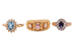 Three gem-set rings in 9ct gold; the first contains an oval-cut topaz within a diamond frame in size