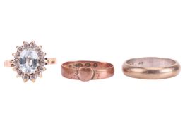 Three gold rings; the first centred with a heart motif leading to a plain band, size L; the other wi