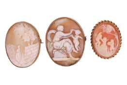 Three cameo brooches; including an oval shell cameo depicting Venus and Cupid, in a yellow metal bro