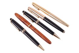 A group of pens comprising a Parker black enamel and gilt fountain pen, a Sheaffer gilt fountain pen