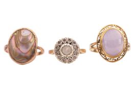 A group of gem-set rings; The first a lavender jade oval cabochon ring, encircled by a border featur