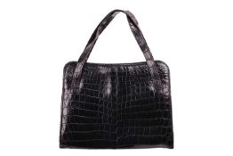 Cartier - a handbag in black crocodile skin leather, circa 1960s, of rectangular shape, with double 
