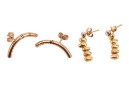 Two pairs of earrings; the first pair each of curved design with grooved details, post and butterfly