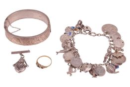 A charm bracelet, with silver and white metal charms; a silver hinged bangle with engraved scrollwor