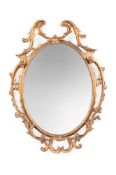 A CARVED GILTWOOD OVAL MIRROR, 18TH CENTURY AND LATER