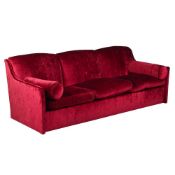 A RED VELVET THREE SEAT SOFA, BY LUCY EADIE INTERIORS, OF RECENT MANUFACTURE