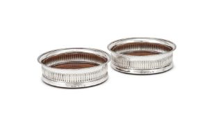 A PAIR OF GEORGE III SILVER BOTTLE COASTERS