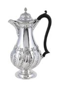 AN EDWARDIAN SILVER LOBED BALUSTER HOT WATER JUG